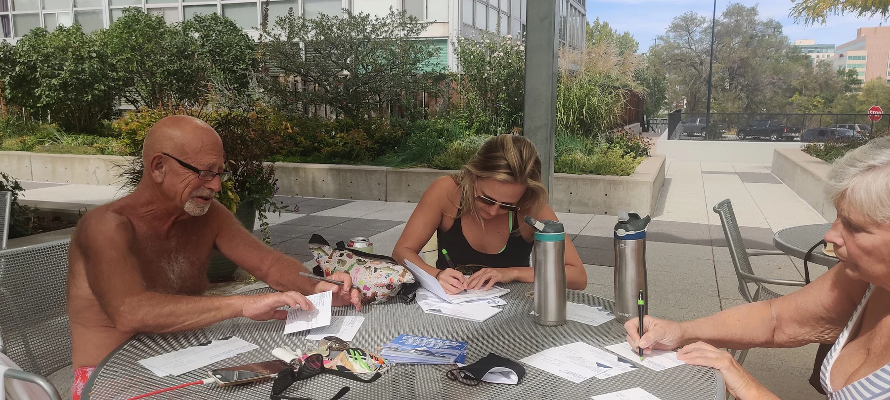 Jake's family writing postcards together beside a pool in 2020