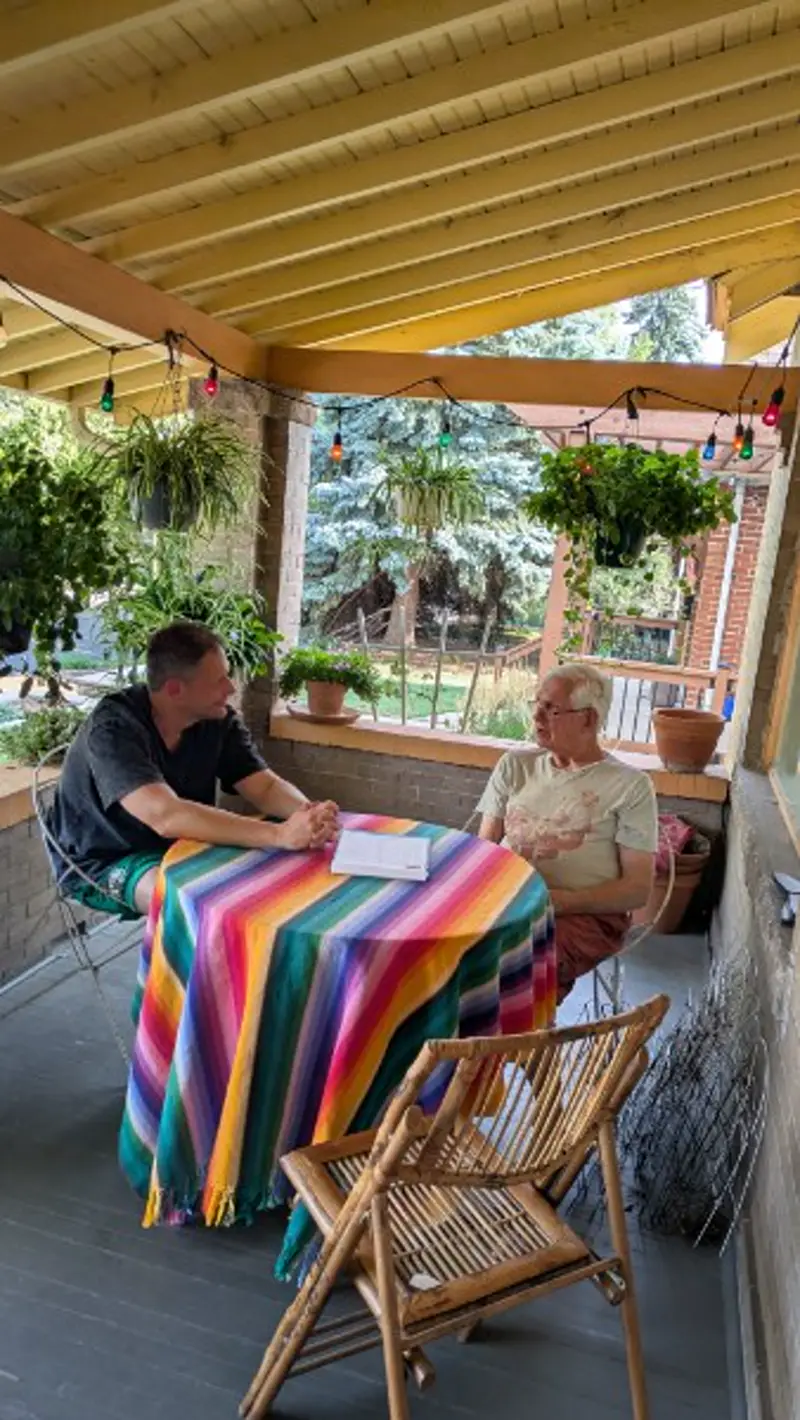 Neighbors talking at a porch table